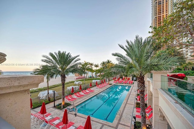 view of swimming pool with a water view and a patio area