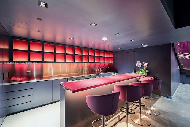 bar featuring stainless steel counters and tasteful backsplash