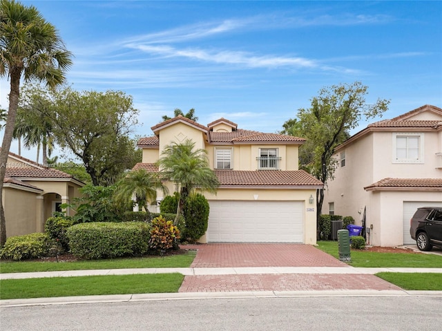 mediterranean / spanish house featuring a garage and a front lawn