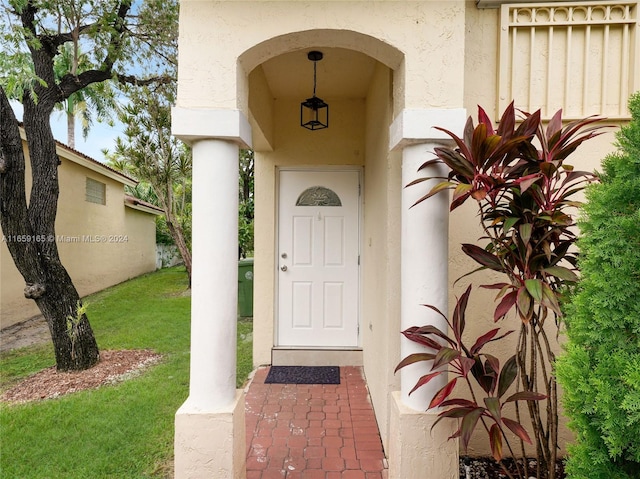 view of exterior entry featuring a yard