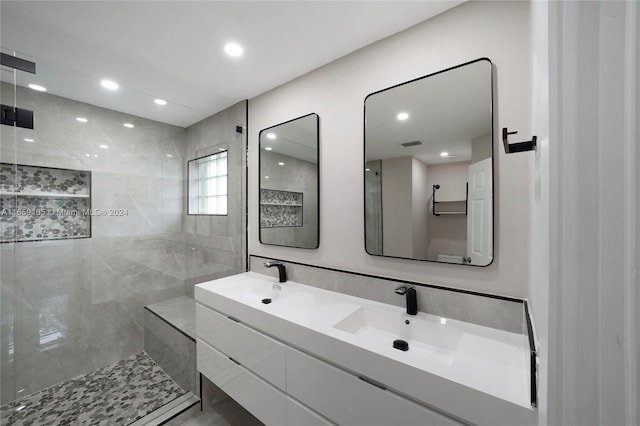 bathroom with a tile shower and vanity