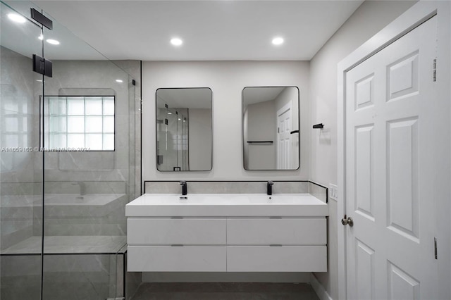 bathroom featuring a shower with door and vanity