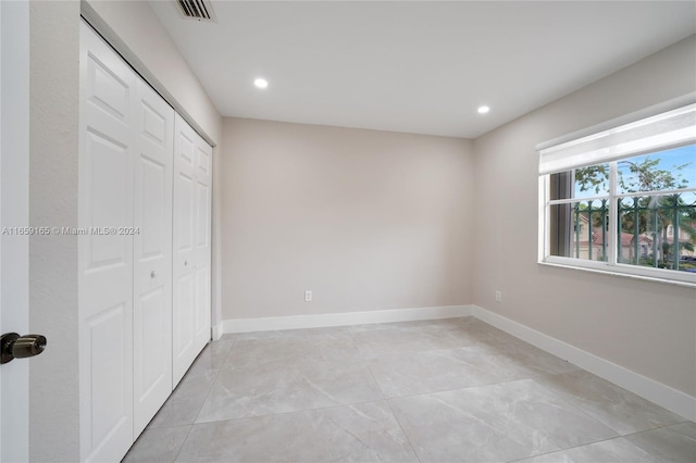 unfurnished bedroom with recessed lighting, a closet, visible vents, and baseboards