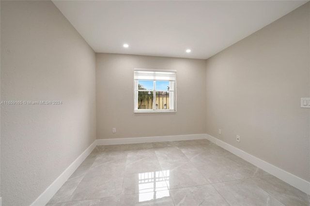 spare room featuring recessed lighting and baseboards