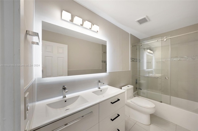 full bathroom with shower / bath combination with glass door, vanity, toilet, backsplash, and tile patterned flooring