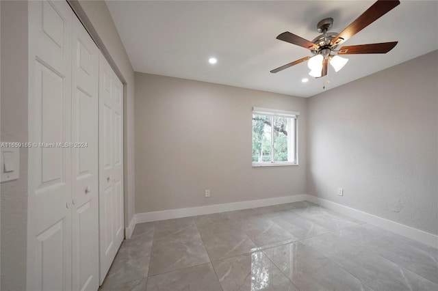 unfurnished bedroom with ceiling fan and a closet