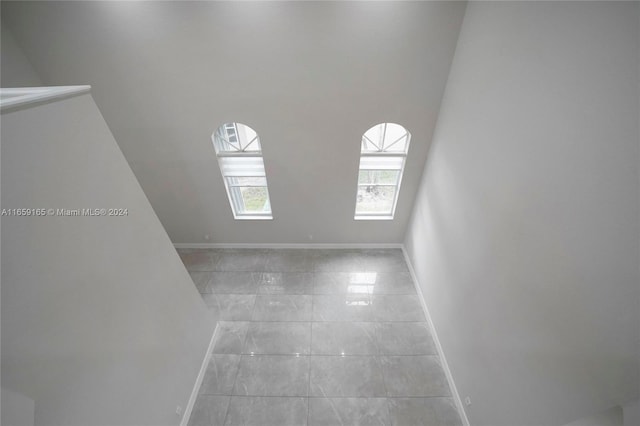 spare room featuring a high ceiling, marble finish floor, and baseboards