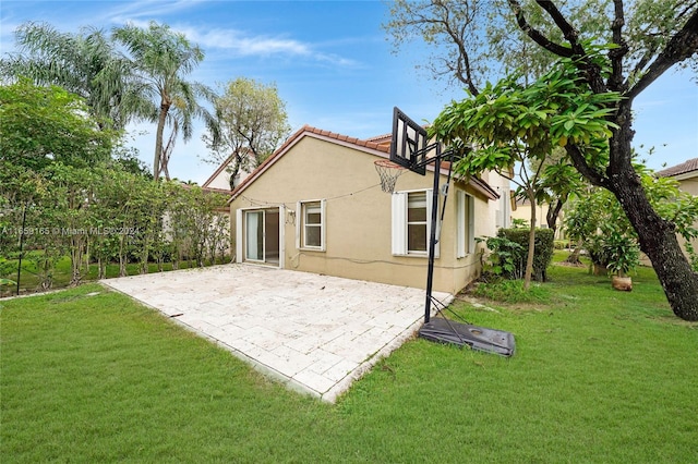 back of property featuring a lawn and a patio