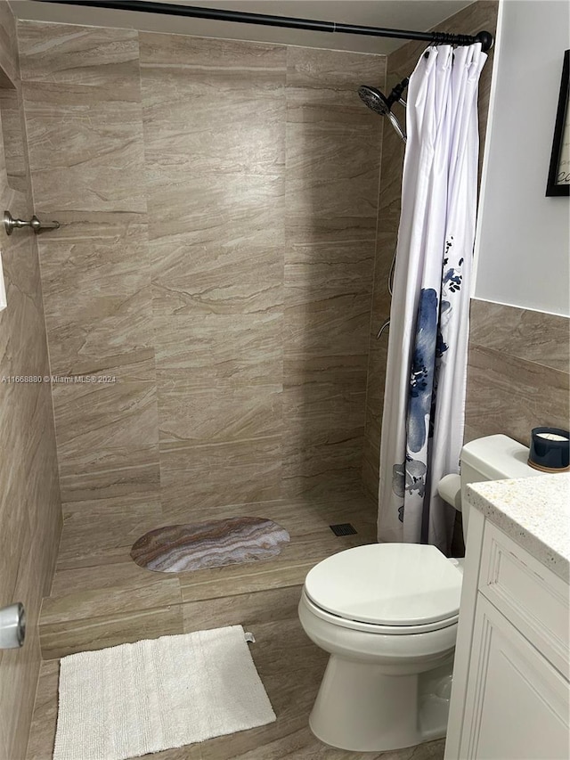 bathroom featuring vanity, tile walls, toilet, and curtained shower