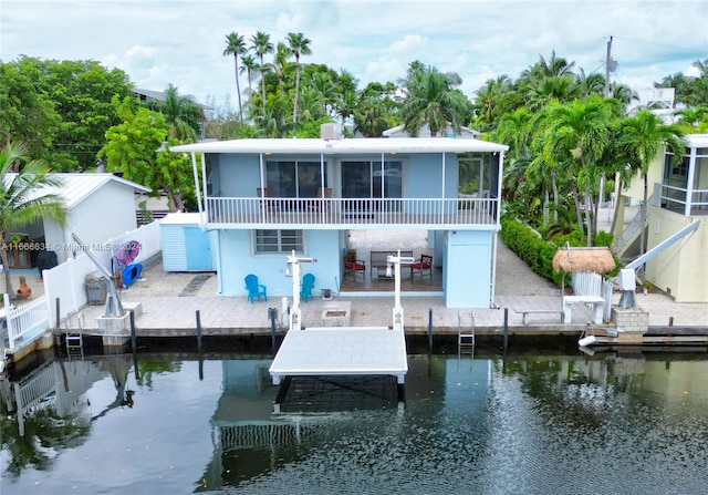 back of property with a patio, a water view, and a sunroom