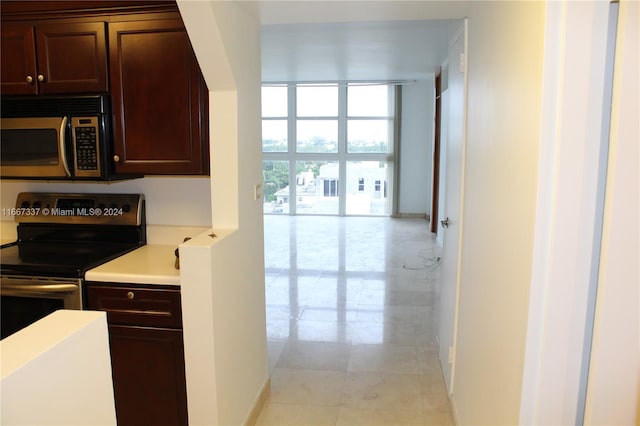 kitchen with expansive windows, dark brown cabinets, and stainless steel appliances