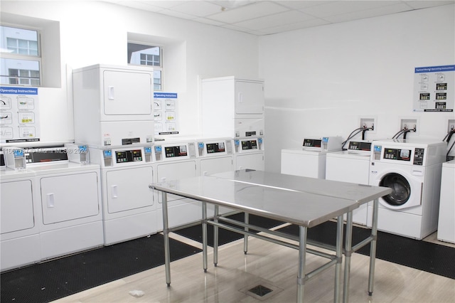 laundry room with light hardwood / wood-style flooring, stacked washer and clothes dryer, and washing machine and dryer