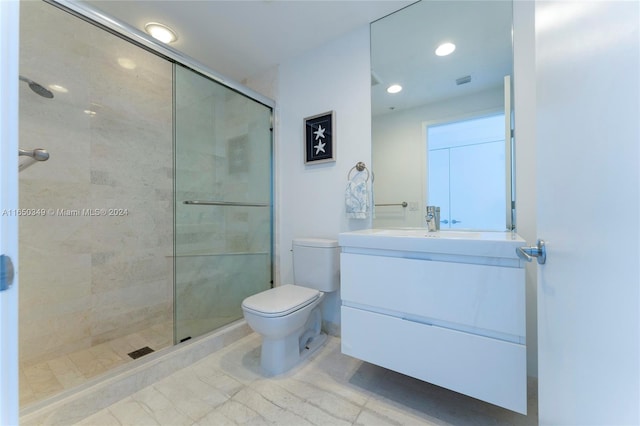 bathroom with vanity, a shower with shower door, and toilet