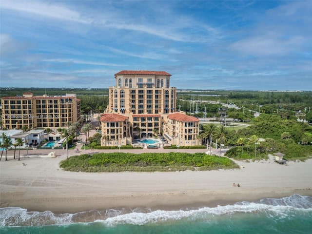 birds eye view of property featuring a water view and a beach view