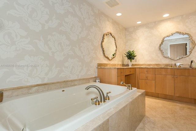 bathroom with vanity, a relaxing tiled tub, and tile patterned floors