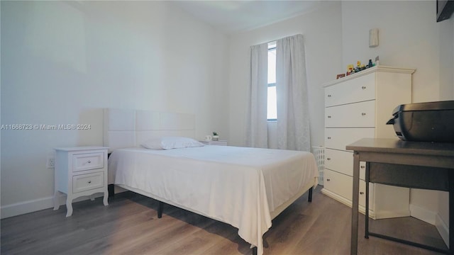 bedroom with dark hardwood / wood-style flooring