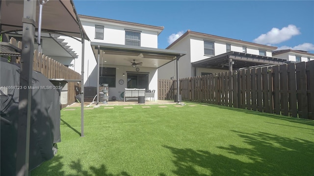 rear view of house featuring a lawn, ceiling fan, and a patio area