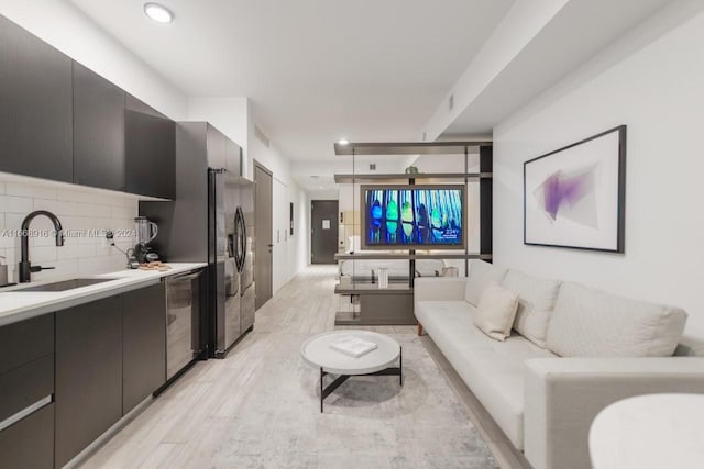 living room featuring light hardwood / wood-style floors and sink