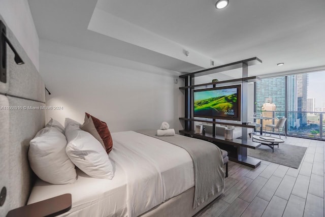 bedroom featuring hardwood / wood-style floors and expansive windows