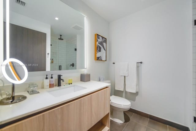 bathroom with vanity, tile patterned flooring, a shower with shower door, and toilet