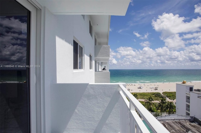 balcony featuring a view of the beach and a water view