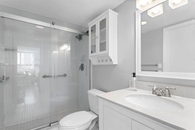 bathroom featuring vanity, toilet, and an enclosed shower