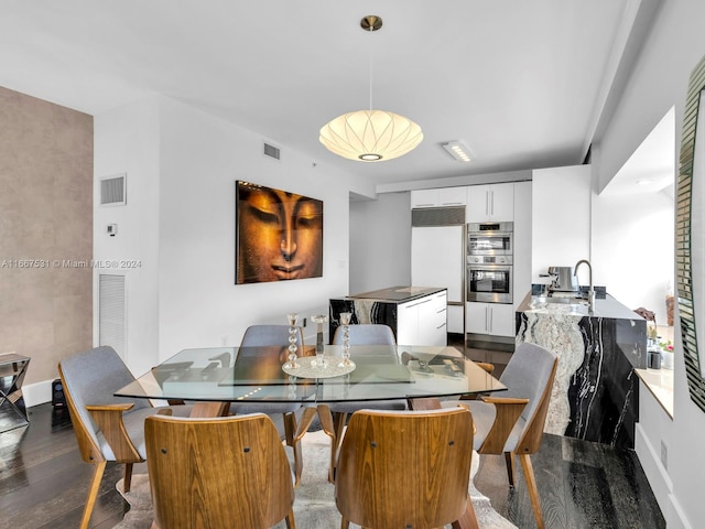 dining space with sink and dark wood-type flooring