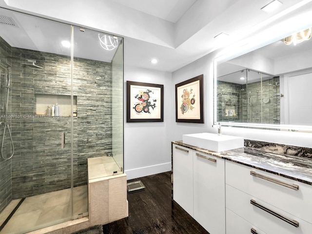 bathroom featuring wood-type flooring, a shower with door, and vanity