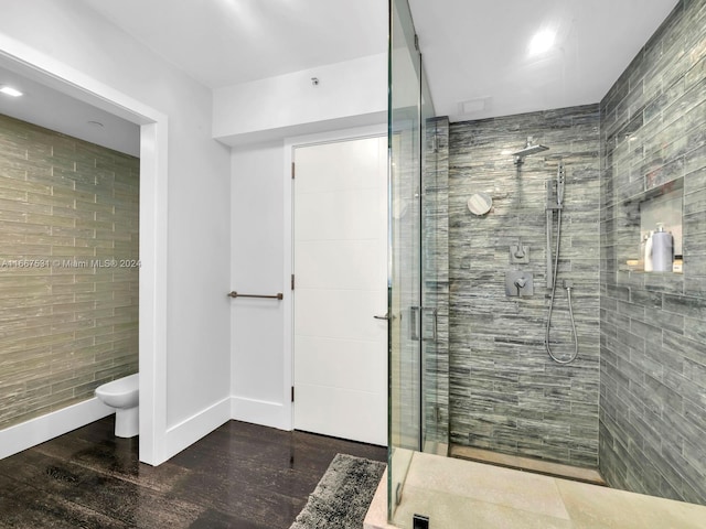 bathroom with a shower with door, toilet, and hardwood / wood-style flooring