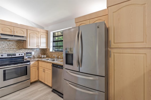 kitchen with tasteful backsplash, lofted ceiling, light hardwood / wood-style flooring, appliances with stainless steel finishes, and light brown cabinetry