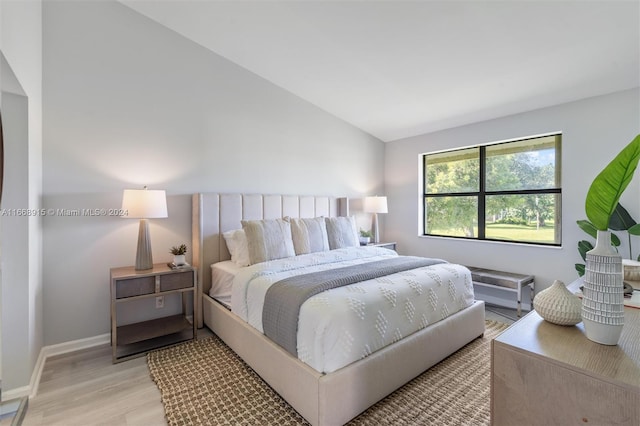 bedroom featuring light hardwood / wood-style flooring and vaulted ceiling