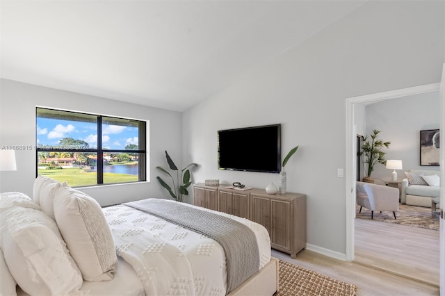 bedroom with lofted ceiling and light hardwood / wood-style floors