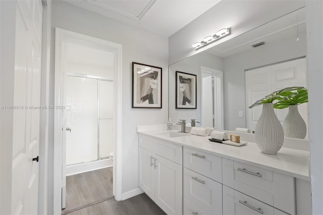 bathroom featuring vanity, wood-type flooring, and an enclosed shower