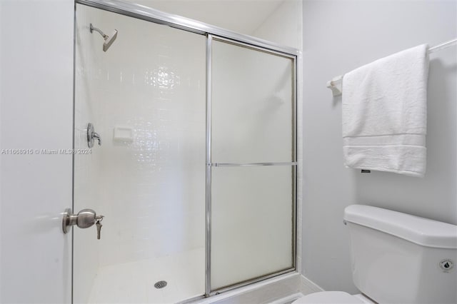 bathroom featuring walk in shower and toilet