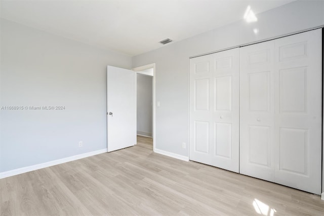 unfurnished bedroom with a closet and light hardwood / wood-style floors