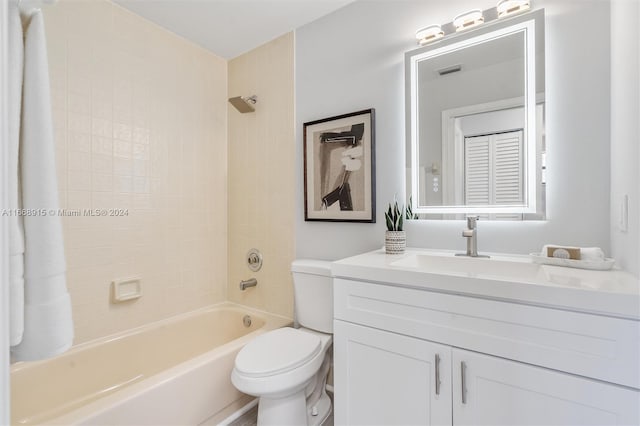 full bathroom featuring vanity, tiled shower / bath combo, and toilet