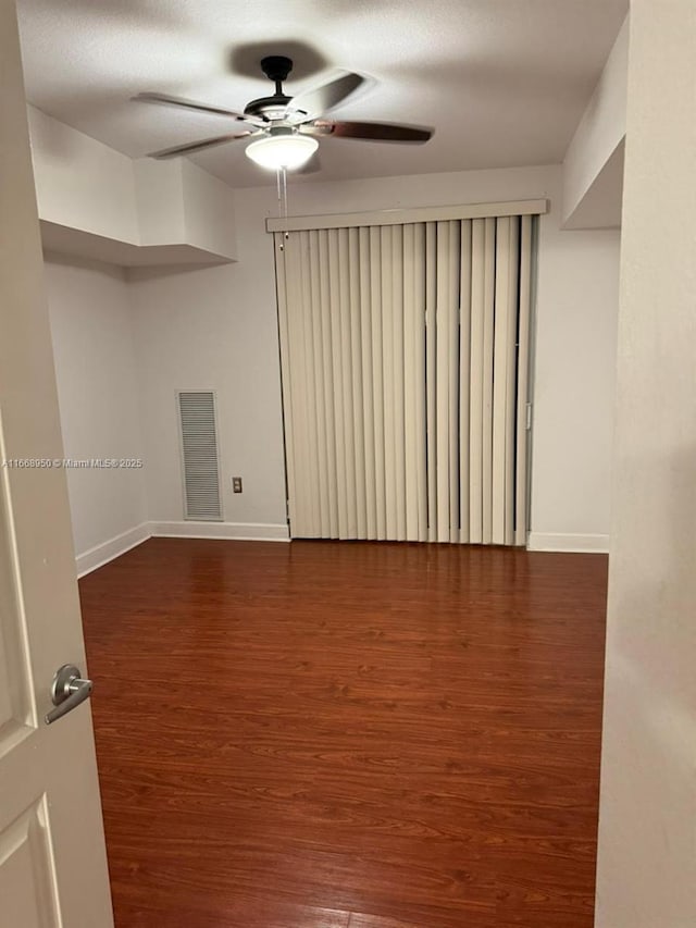 empty room featuring ceiling fan, dark hardwood / wood-style flooring, and a textured ceiling