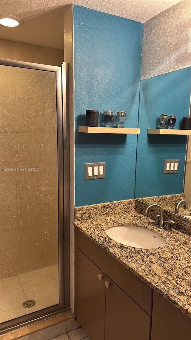 bathroom featuring tile patterned flooring, vanity, and an enclosed shower