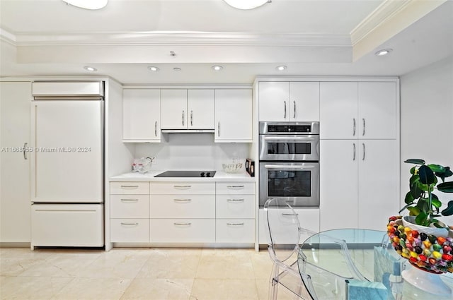 kitchen with paneled refrigerator, a raised ceiling, double oven, black electric stovetop, and ornamental molding