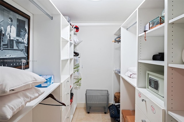 walk in closet with light tile patterned floors