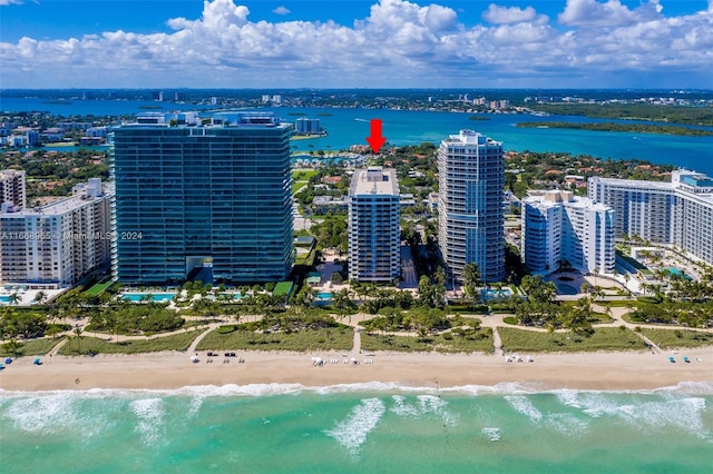 drone / aerial view featuring a water view, a city view, and a view of the beach