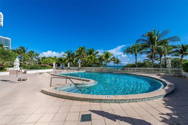 community pool featuring fence and a patio