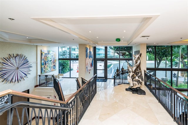 interior space with visible vents, expansive windows, a raised ceiling, tile patterned floors, and recessed lighting