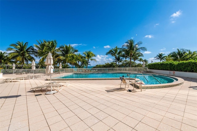 community pool featuring fence and a patio area