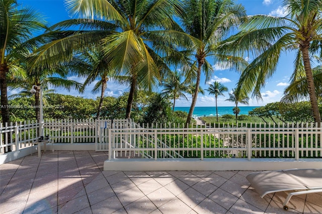view of patio / terrace with fence and a water view