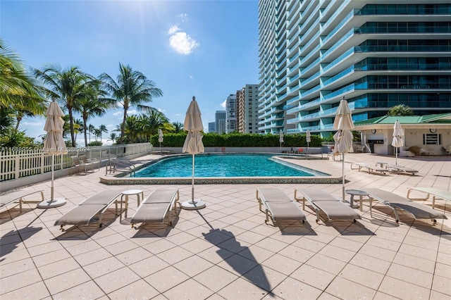 community pool with fence and a patio area