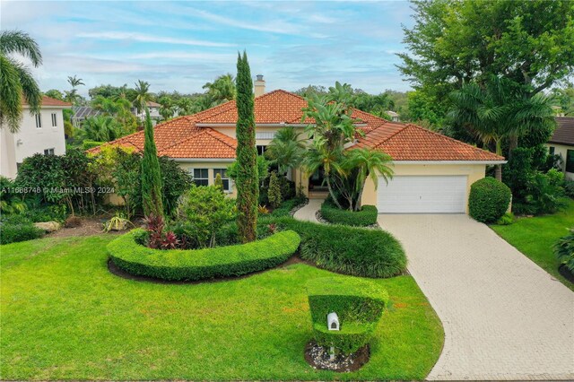 mediterranean / spanish-style house with a garage and a front yard