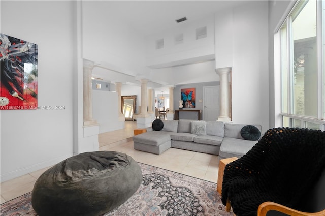 living room with decorative columns and light tile patterned floors