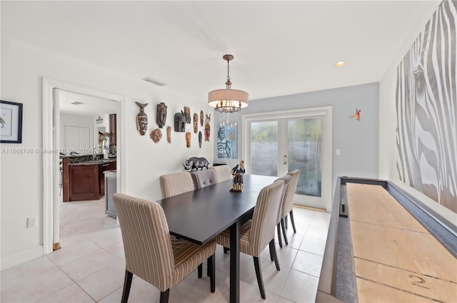 dining area featuring light tile patterned flooring, an inviting chandelier, sink, and french doors