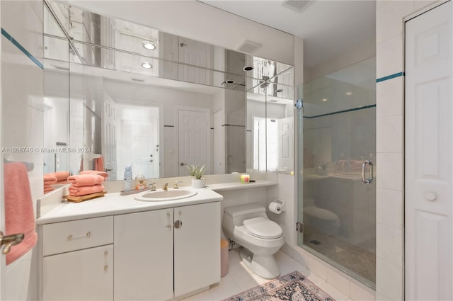 bathroom with tile patterned flooring, walk in shower, vanity, and toilet